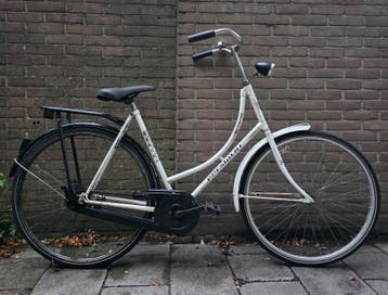 Witte President-fiets met een laag frame en 28-inch wielen.