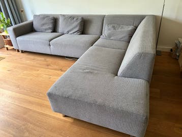 Gratis - Grijze stoffen hoekbank met chaise longue