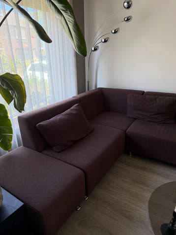 Comfortabele bruine hoekbank met hocker