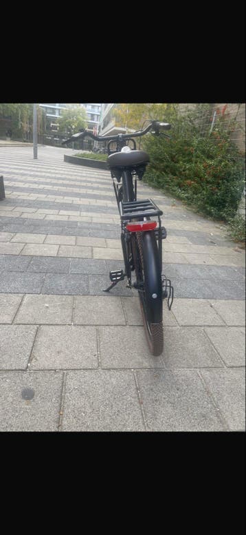 Zwarte damesfiets met voordrager en bruine banden