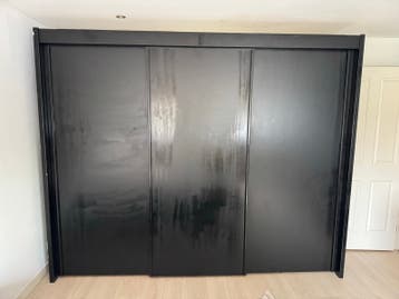 Grote zwarte kledingkast met schuifdeuren