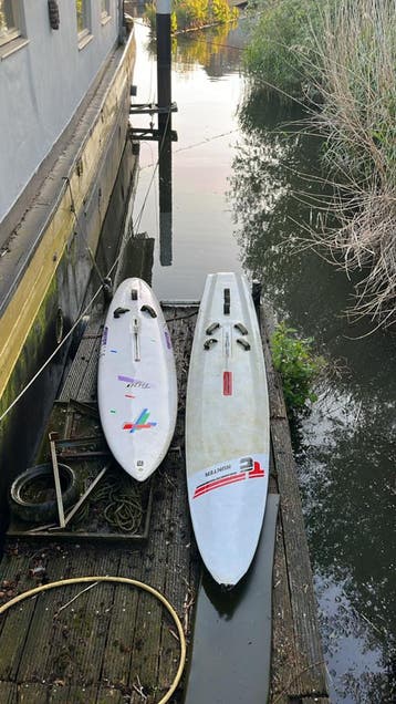 Twee windsurfplanken (achter boot of surfen)