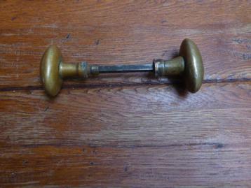 twee antieke koperen deurknoppen.