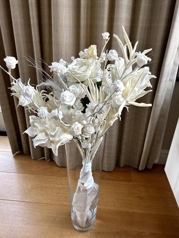 Hoge glazen vaas met witte kunstbloemen