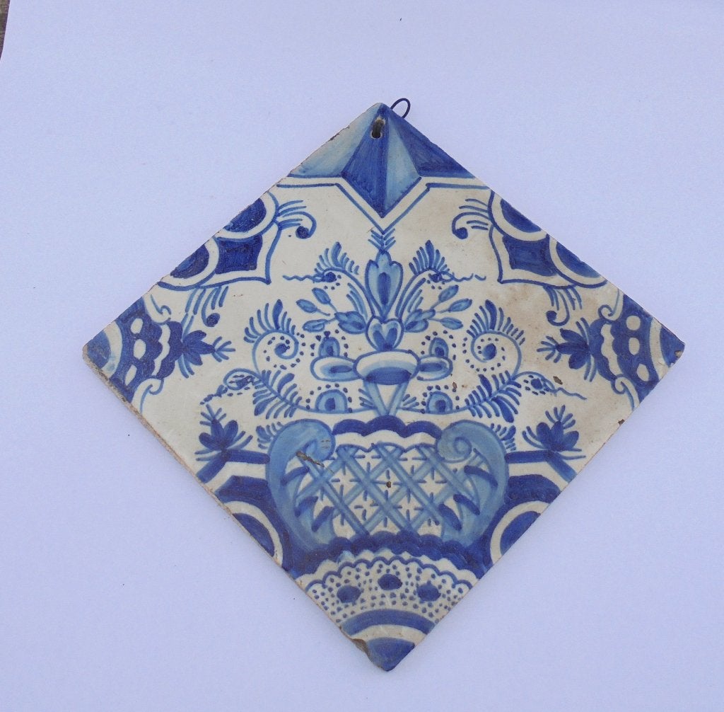 Oud Hollandse tegel met florale motieven en ophangoogje., Antiek en Kunst, Ophalen of Verzenden