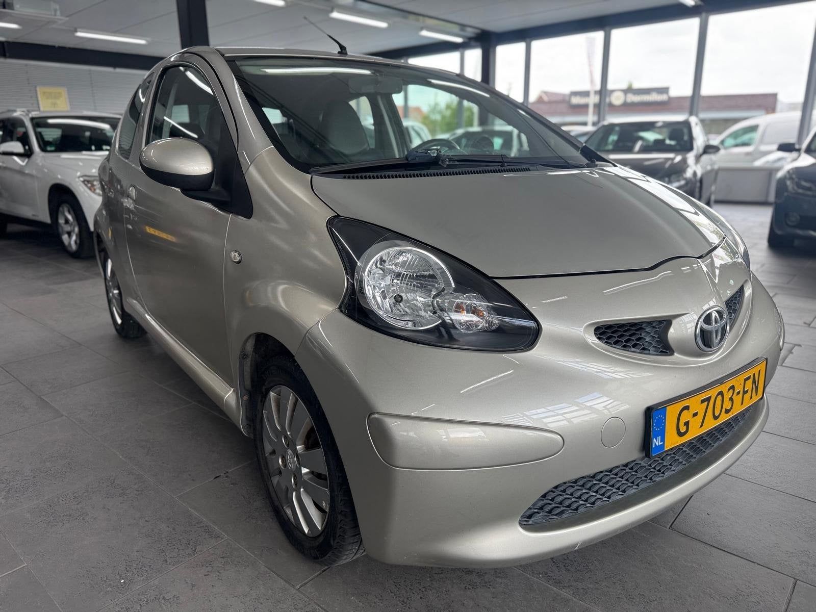 Toyota Aygo 1.0-12V + airco elektrische pakket half leer lm-, Auto's, Voorwielaandrijving, Gebruikt, Bruin, 4 stoelen