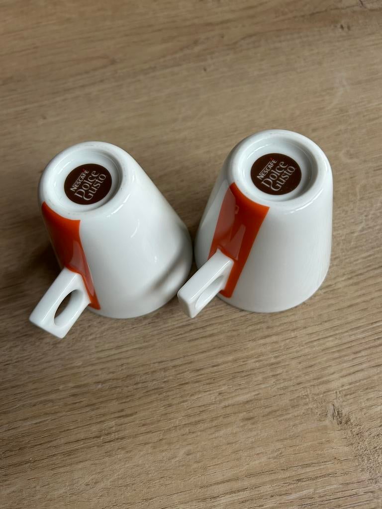 Twee Dolce Gusto kopjes wit met oranje streep, Ophalen of Verzenden, Zo goed als nieuw, Overige stijlen, Kop(pen) en/of Schotel(s)