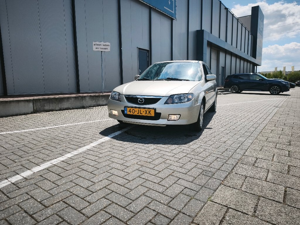 Mazda 323 1.6 F Touring AUT 2002 Grijs, Auto's, Stof, Zwart, 400 kg, 49 €/maand