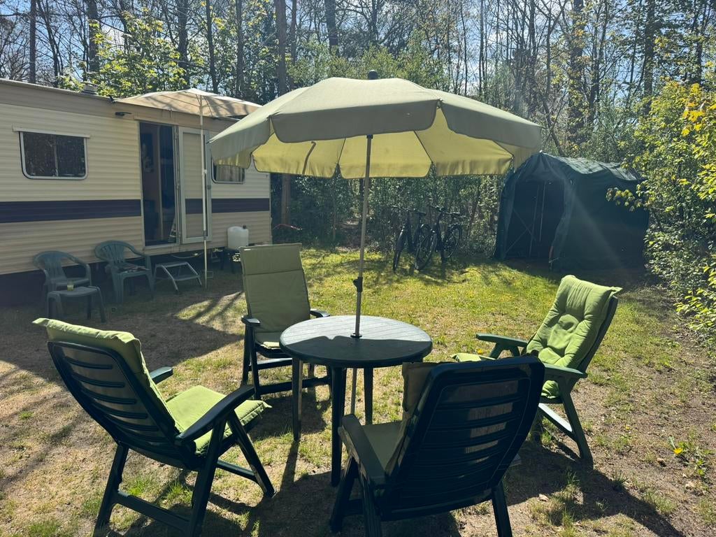 Knusse caravan, zowel zon als schaduw in een rustig gedeelte