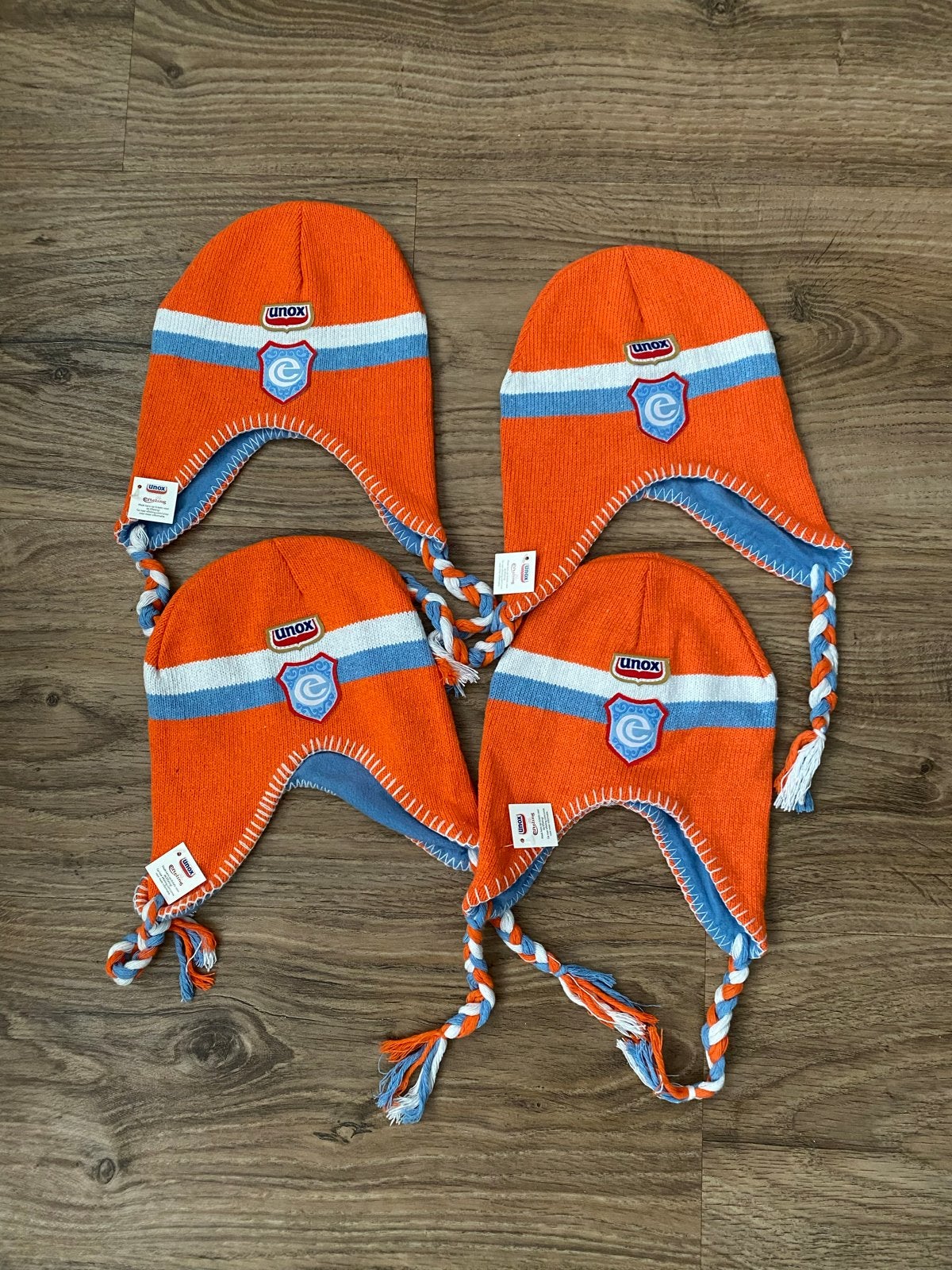 4 Unox wintermutsen Efteling oranje/blauw/wit met vlechtjes, Ophalen of Verzenden, Zo goed als nieuw, Muts