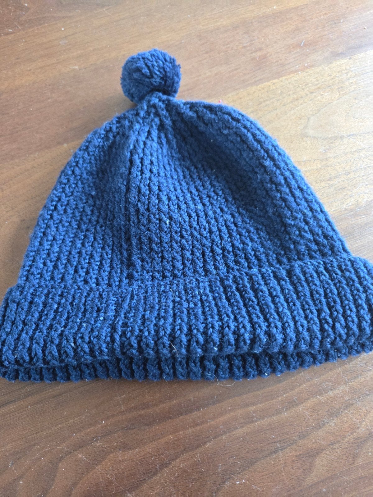 Donkerblauwe gebreide muts met pompon, Ophalen of Verzenden, Zo goed als nieuw, Muts