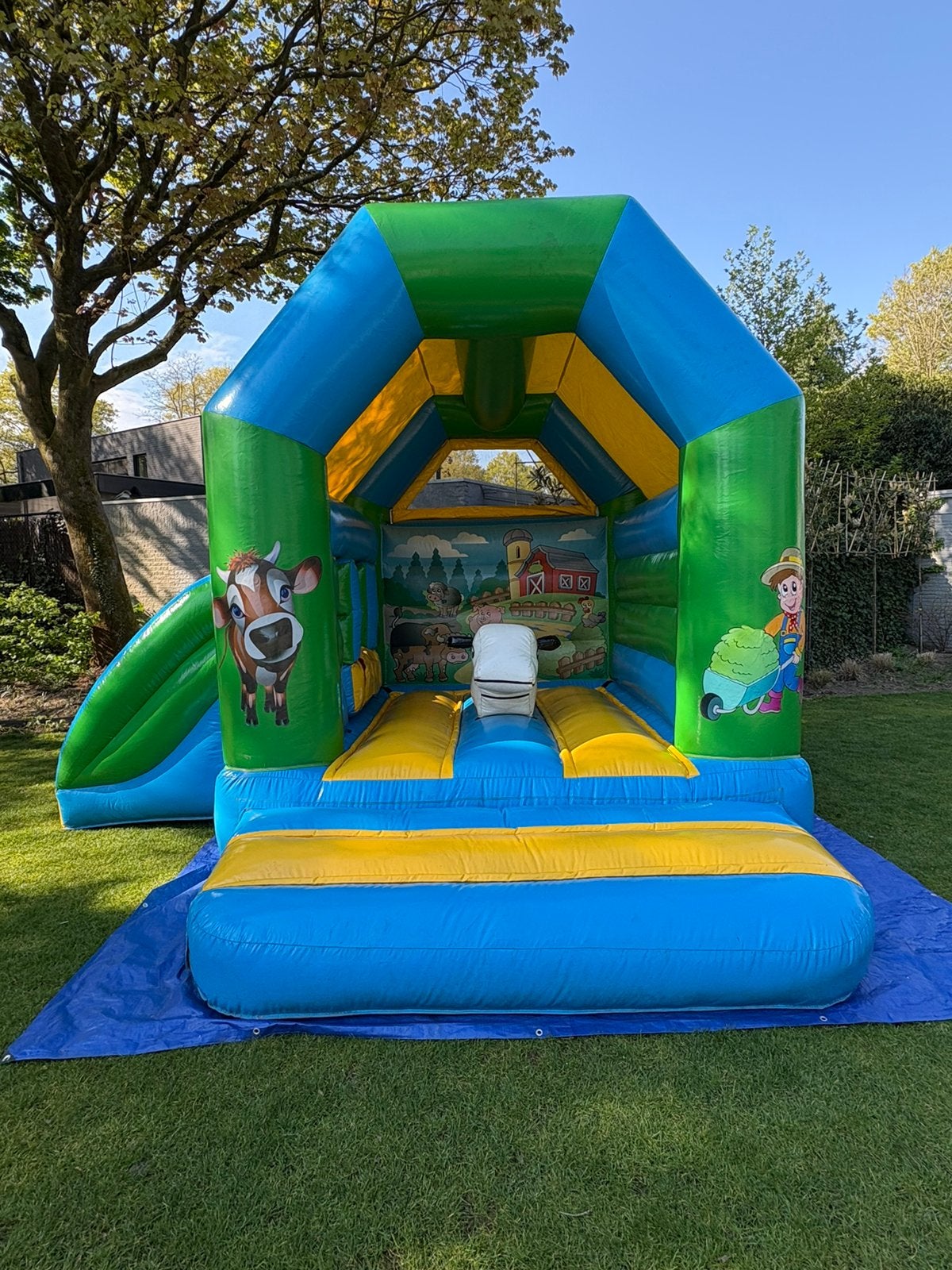 Springkussen te huur met glijbaan en ‘speel koe’, Hobby en Vrije tijd, Feestartikelen | Verhuur, Ophalen of Verzenden