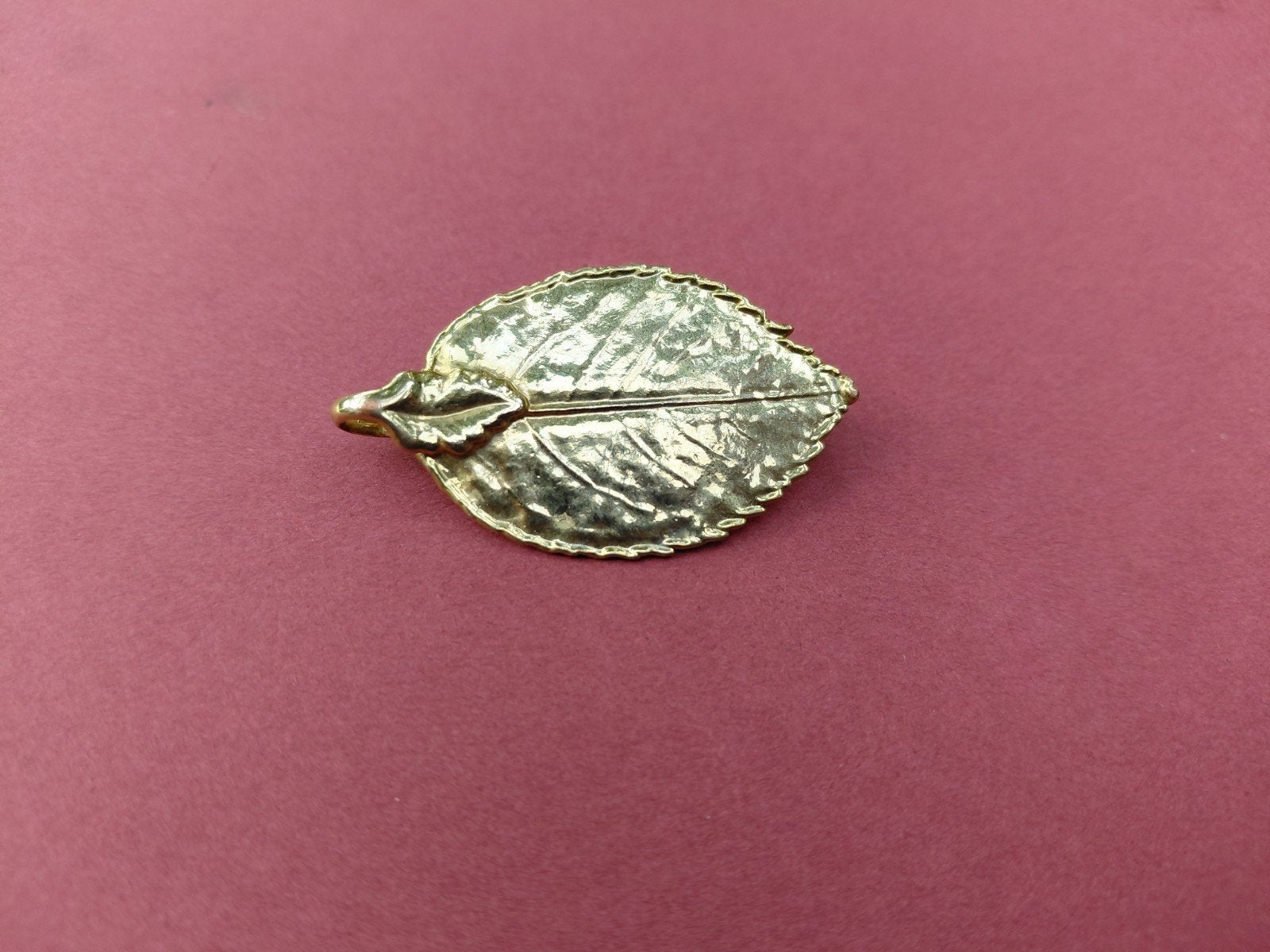 Fraaie goudkleurige broche in bladvorm. Merk:  DPR., Overige materialen, Ophalen of Verzenden, Zo goed als nieuw, Bloem of Plant