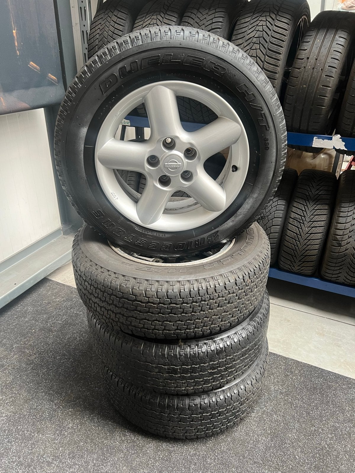 Nissan 16 inch velgen met Bridgestone Dueler H/T banden, Ophalen, 16 inch, Banden en Velgen, All Season