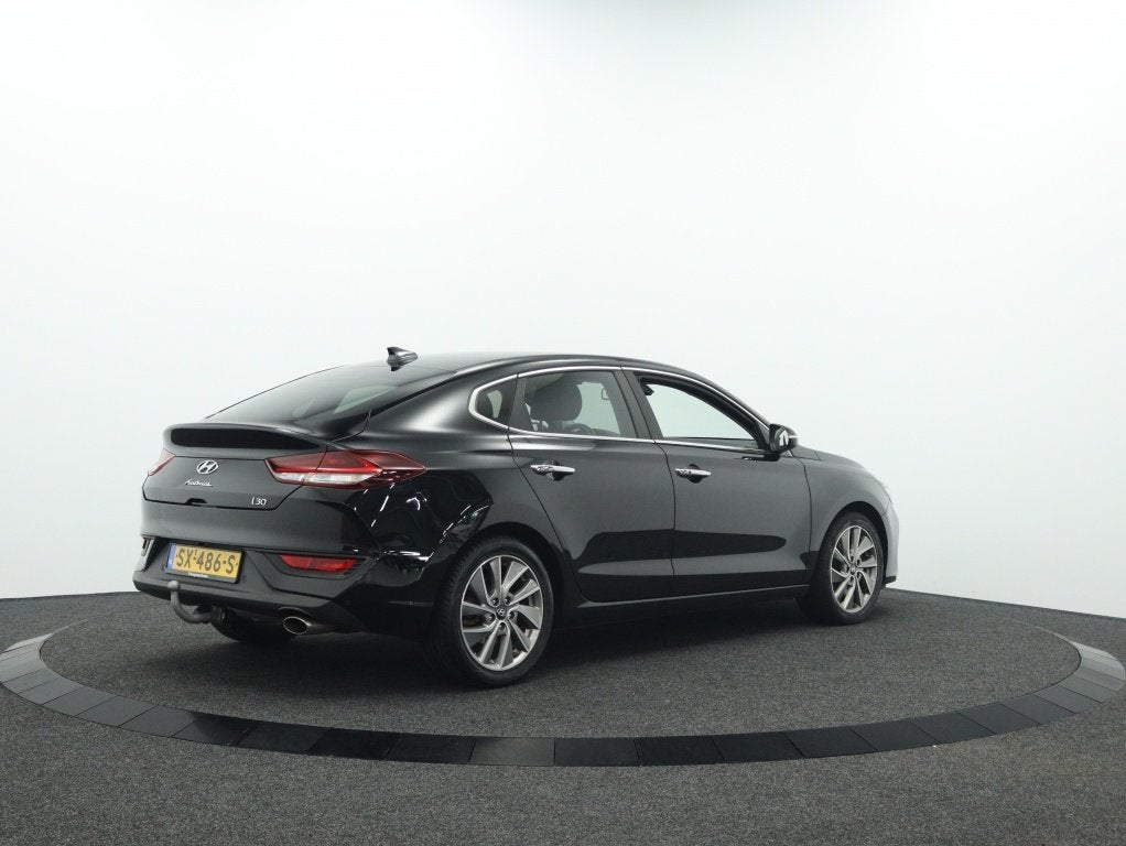 Hyundai i30 Fastback 1.0 T-GDI Premium | Trekhaak | Navigati, Auto's, Keurmerk '100% Onderhouden', 12 maanden, Gebruikt, Leder en Stof