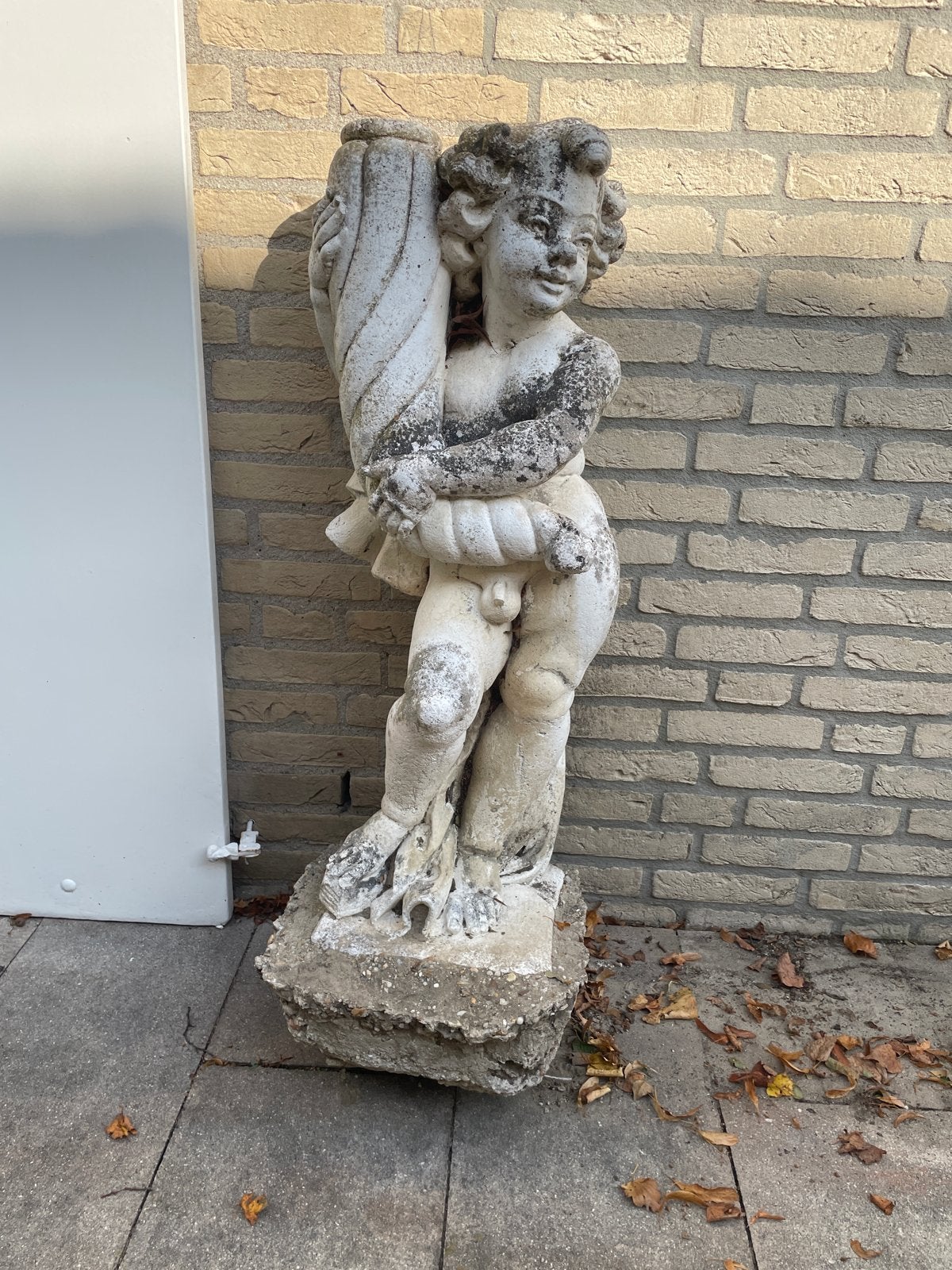 Antiek stenen beeld van putto met vaas