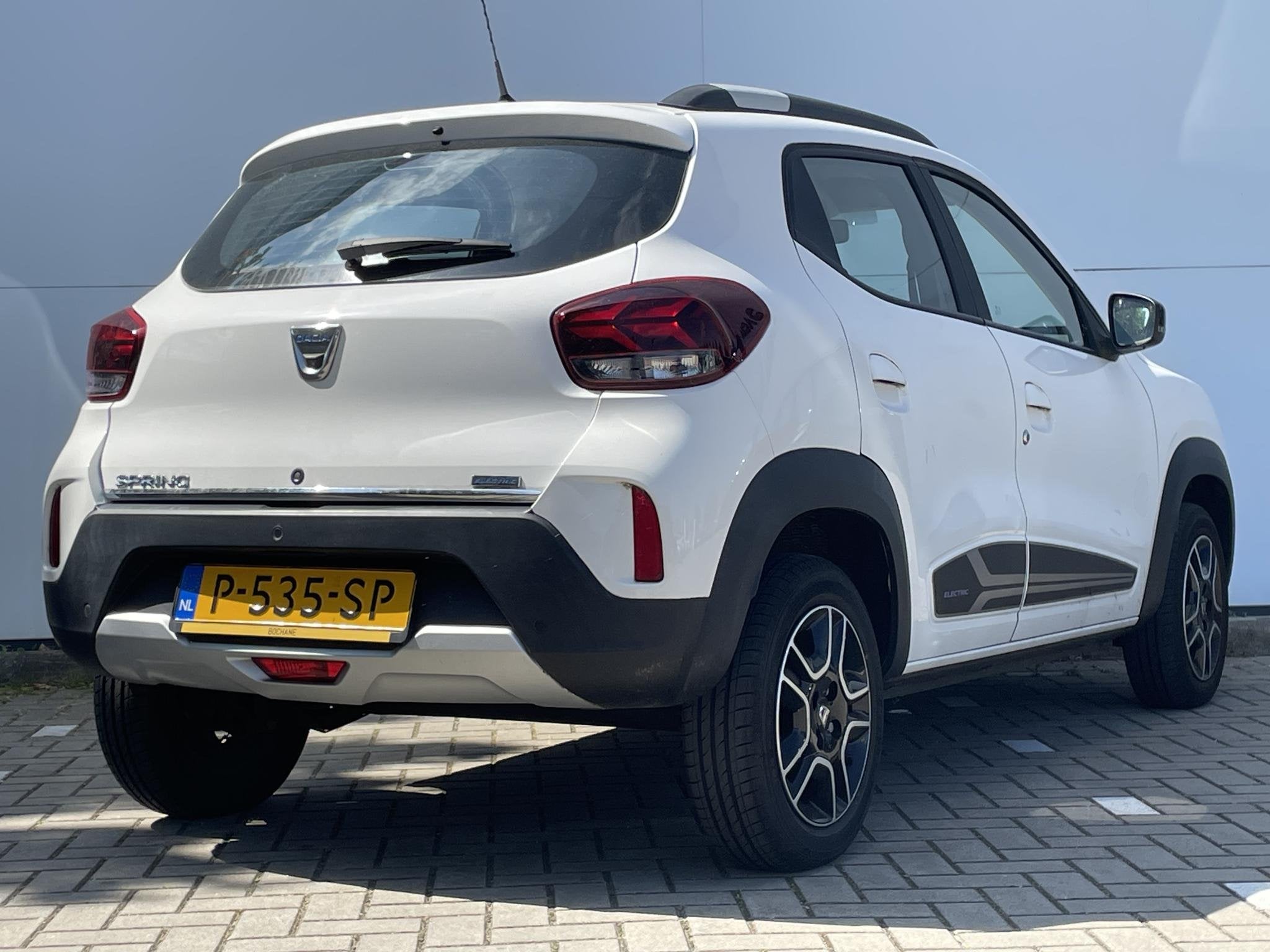 Dacia Spring Comfort Plus (Orange Pack) 27 kWh | Navigatie |, Auto's, Dacia, Gebruikt, Leder en Stof, Wit, Te koop