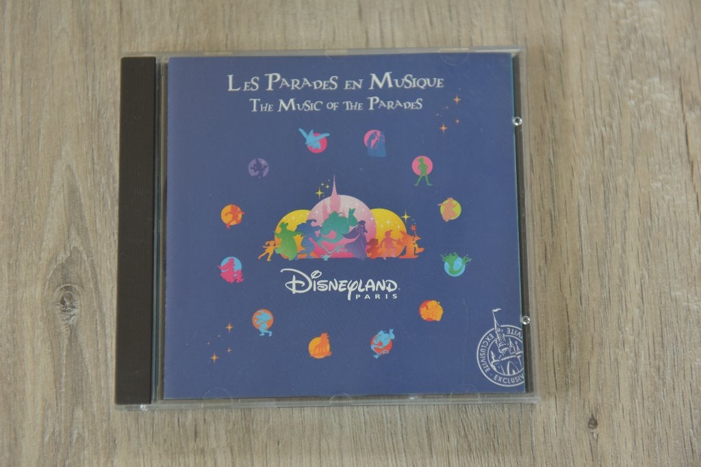 DISNEYLAND PARIS -- THE MUSIC OF THE PARADES, Inclusief boekje, Ophalen of Verzenden, Zo goed als nieuw, 3 tot 5 jaar