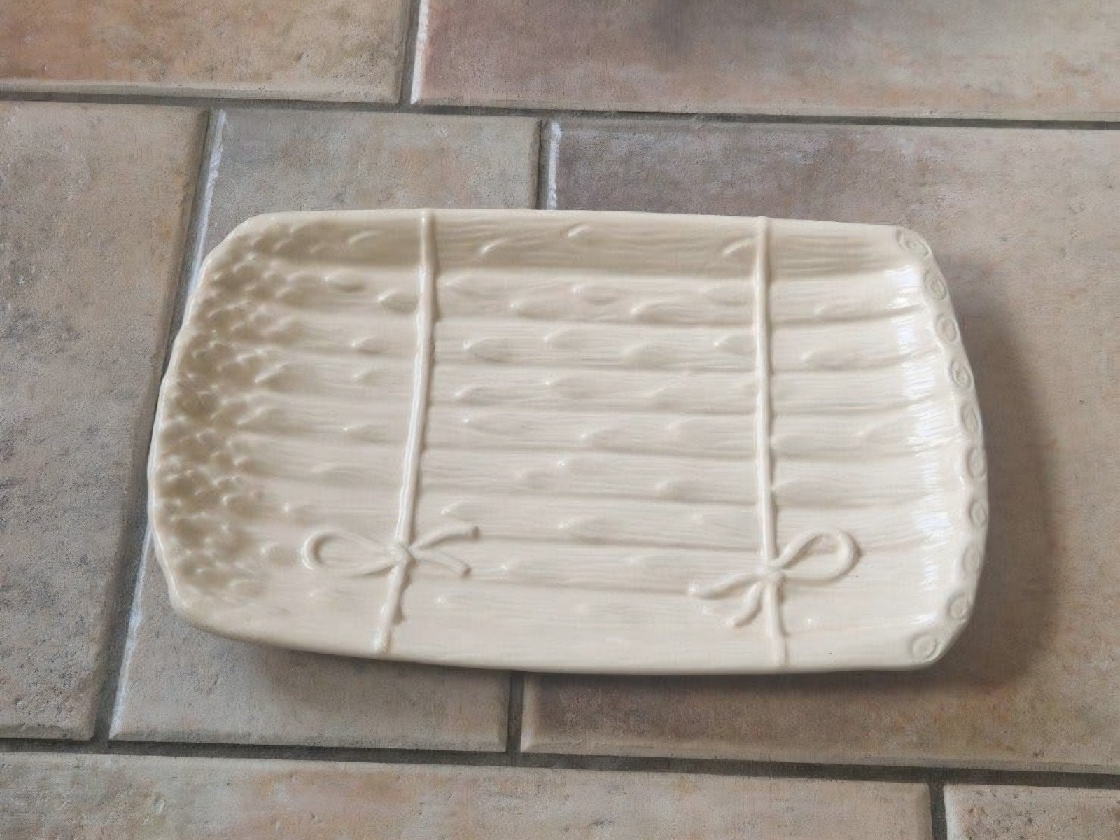 Crèmekleurige keramische schaal met strikjes, Huis en Inrichting, Ophalen, Gebruikt, Porselein of Keramiek, Schaal