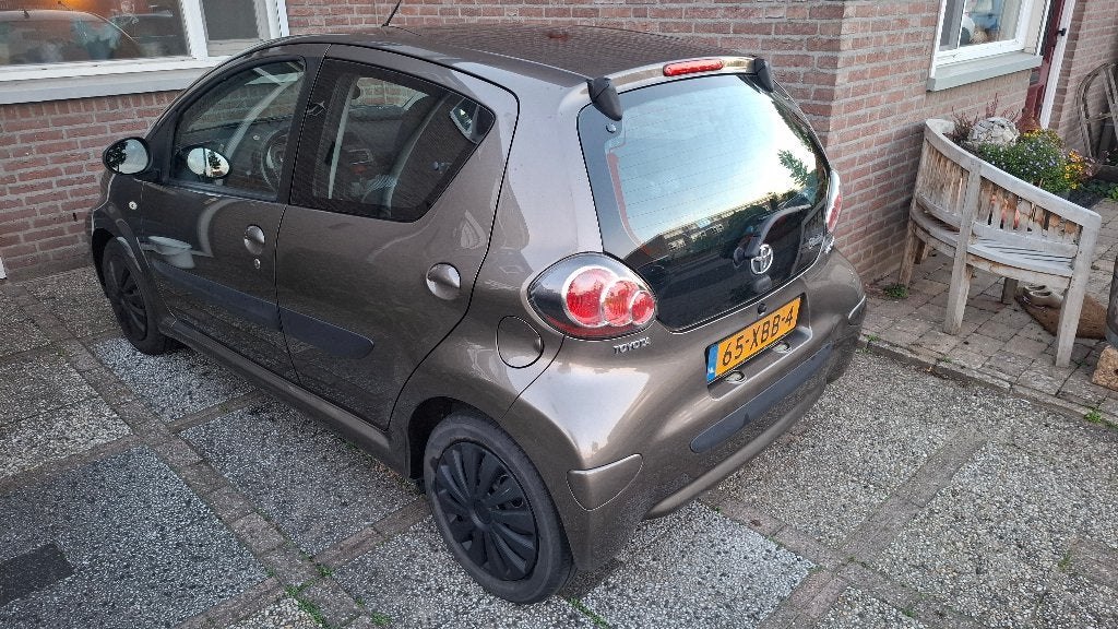 Toyota Aygo 1.0 12V Vvt-i 5DRS 2012 Bruin, Auto's, Voorwielaandrijving, Stof, Bruin, 4 stoelen