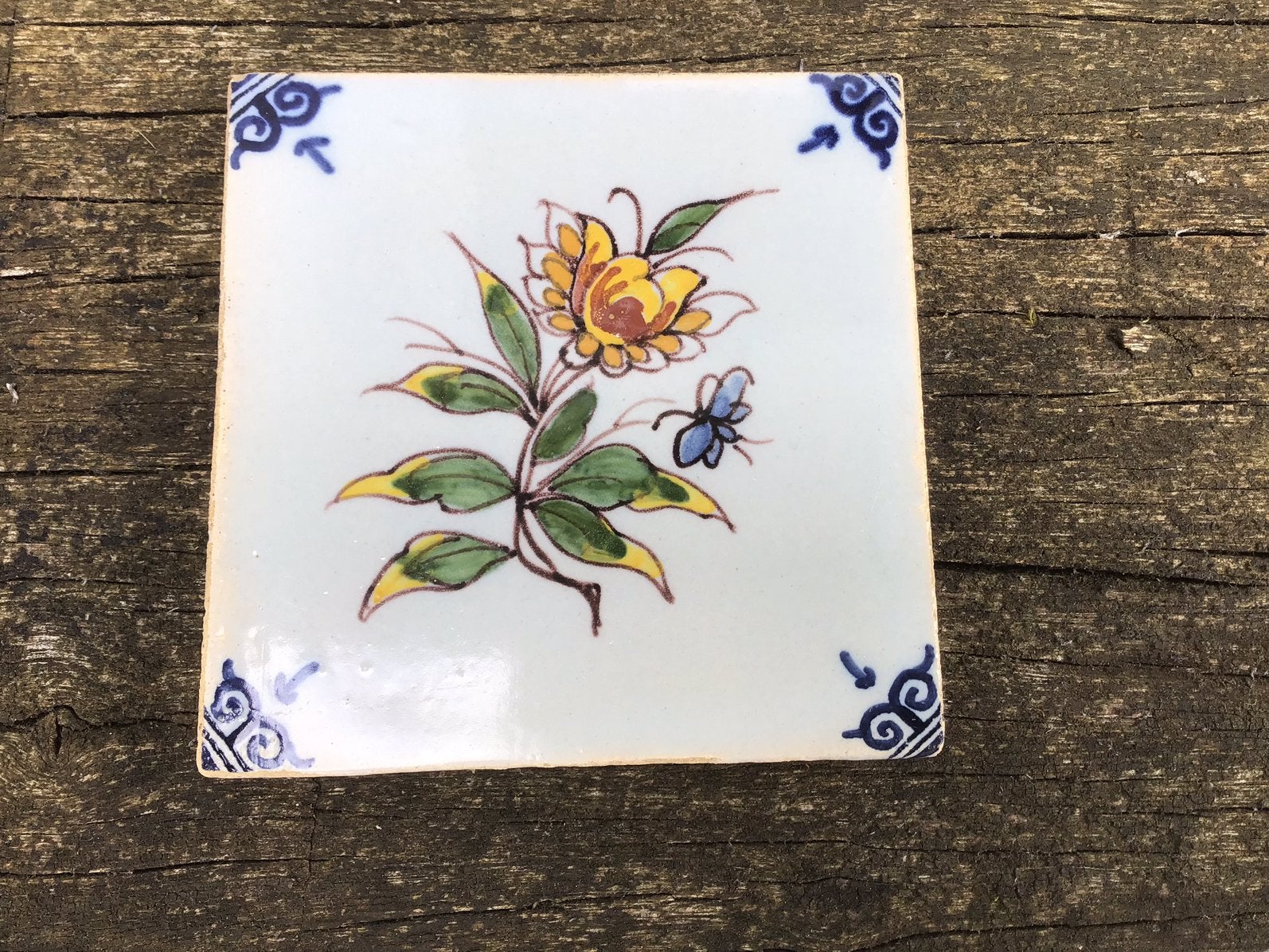 Kleine oude Makkum tegel met bloemdecor, Ophalen of Verzenden