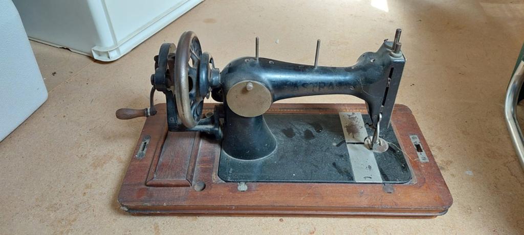 ASTRA :Antieke handnaaimachine op houten onderstel, Ophalen