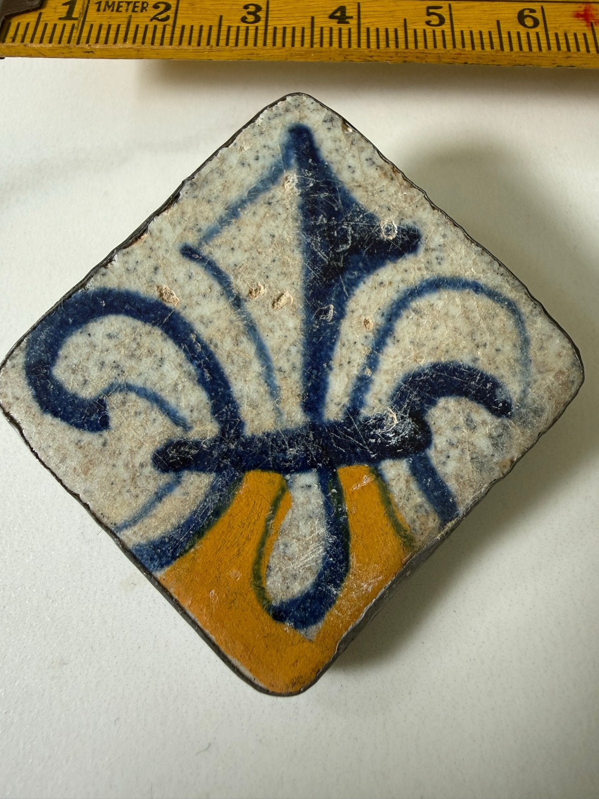 Handgemaakte broche met Franse lelie van antieke tegel, Overige materialen, Gebruikt, Minder dan 4 cm, Verzenden