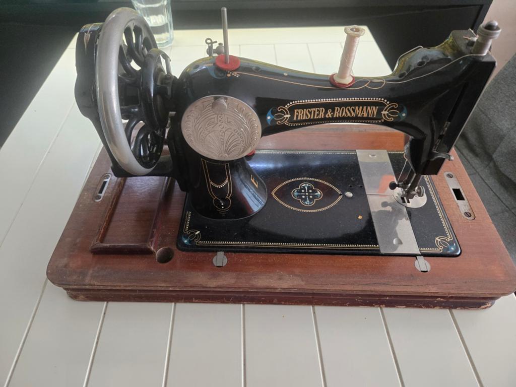 Antieke naaimachine in houten kist, Ophalen