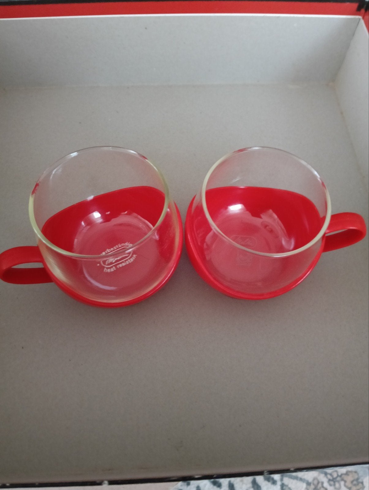 2 Melitta hittebestendige glazen kopjes met rode houders, Ophalen, Overige merken, Vintage, Kop(pen) en/of Schotel(s)