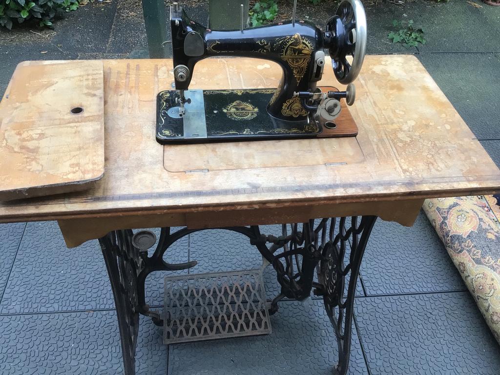 Antieke naaimachine met houten tafel en gietijzeren onderste, Ophalen
