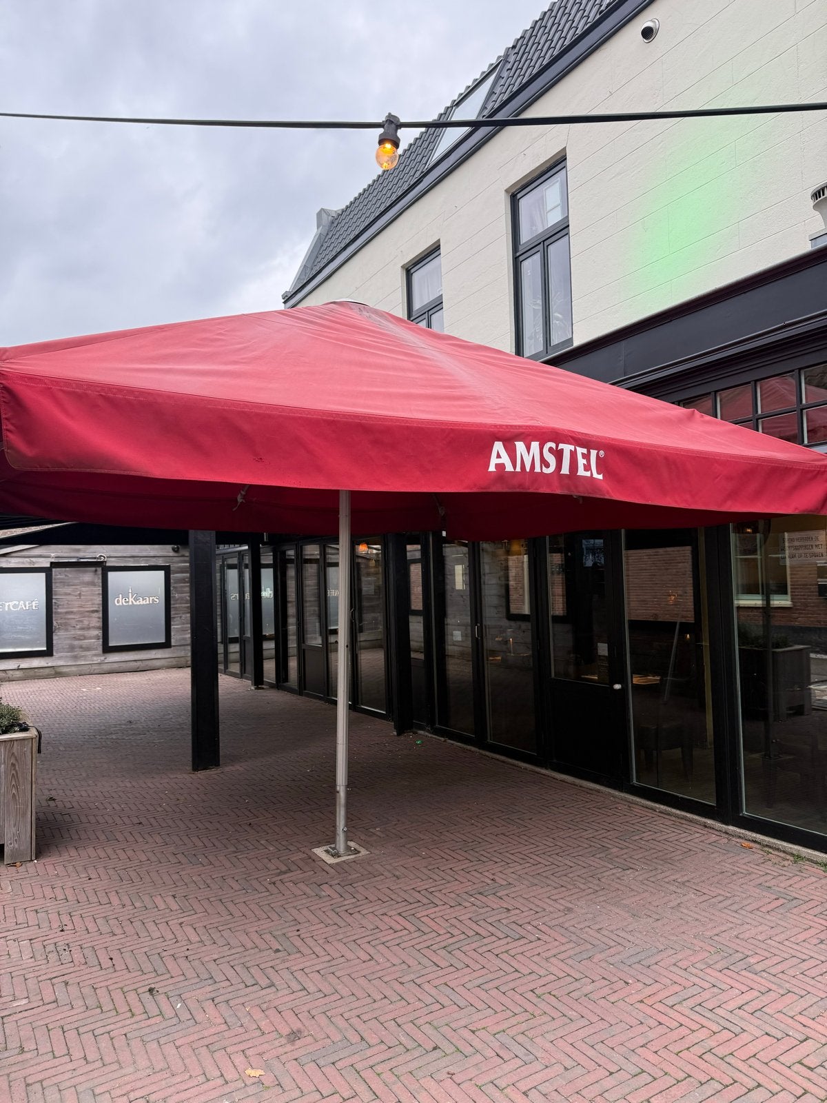 Grote Amstel Parasol 4x4m met ingegraven voet, Ophalen, Gebruikt, Meer dan 4 meter, Stokparasol