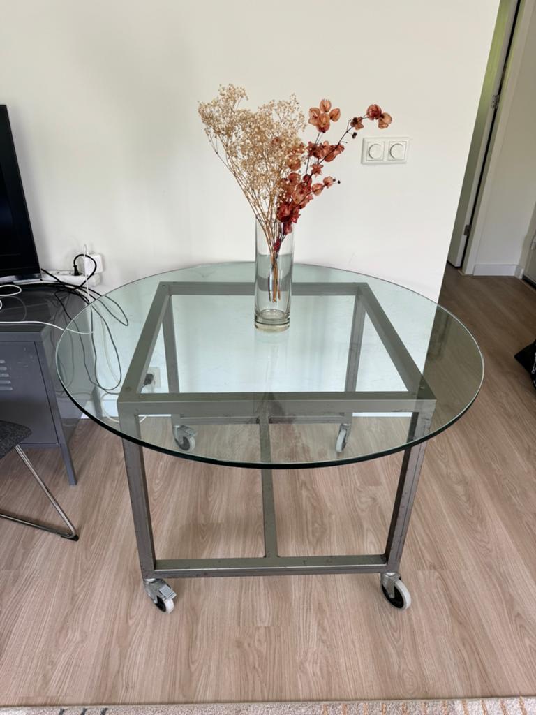 Glazen ronde tafel met metalen onderstel op wieltjes, Huis en Inrichting, Tafels | Eettafels, Ophalen, Gebruikt, 100 tot 150 cm