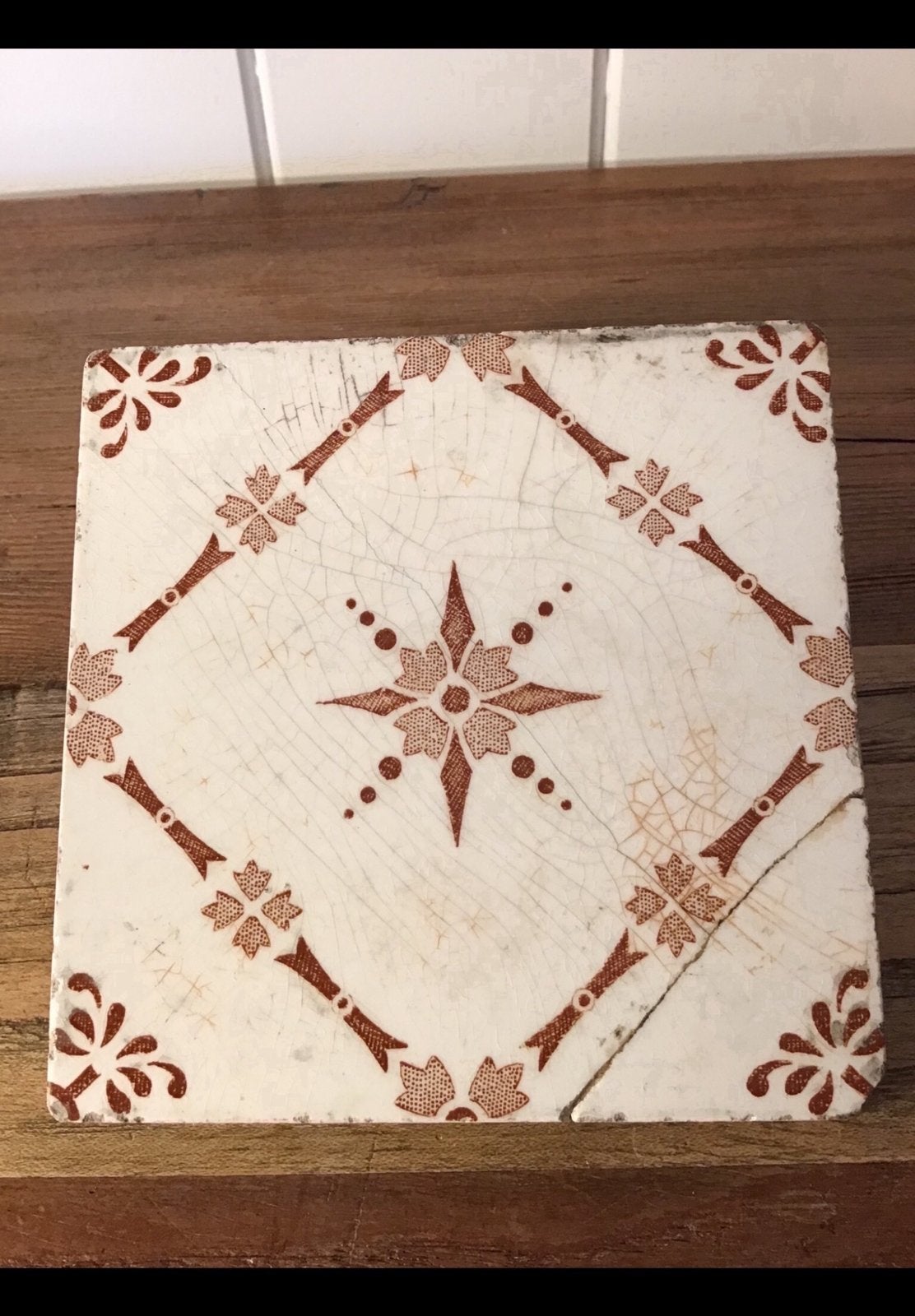 Een oude wandtegel met ster motief in kleur bruin beschadigd, Ophalen of Verzenden