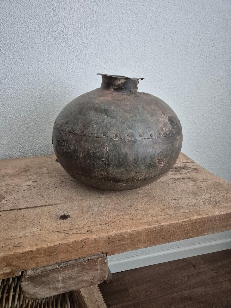 Metalen oude Nepalese waterkruik, Ophalen