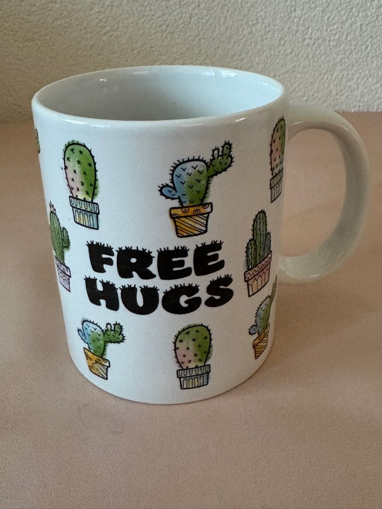 Witte koffiemok met cactussen en tekst Free Hugs, Onbekend., Keramiek, Ophalen of Verzenden, Zo goed als nieuw