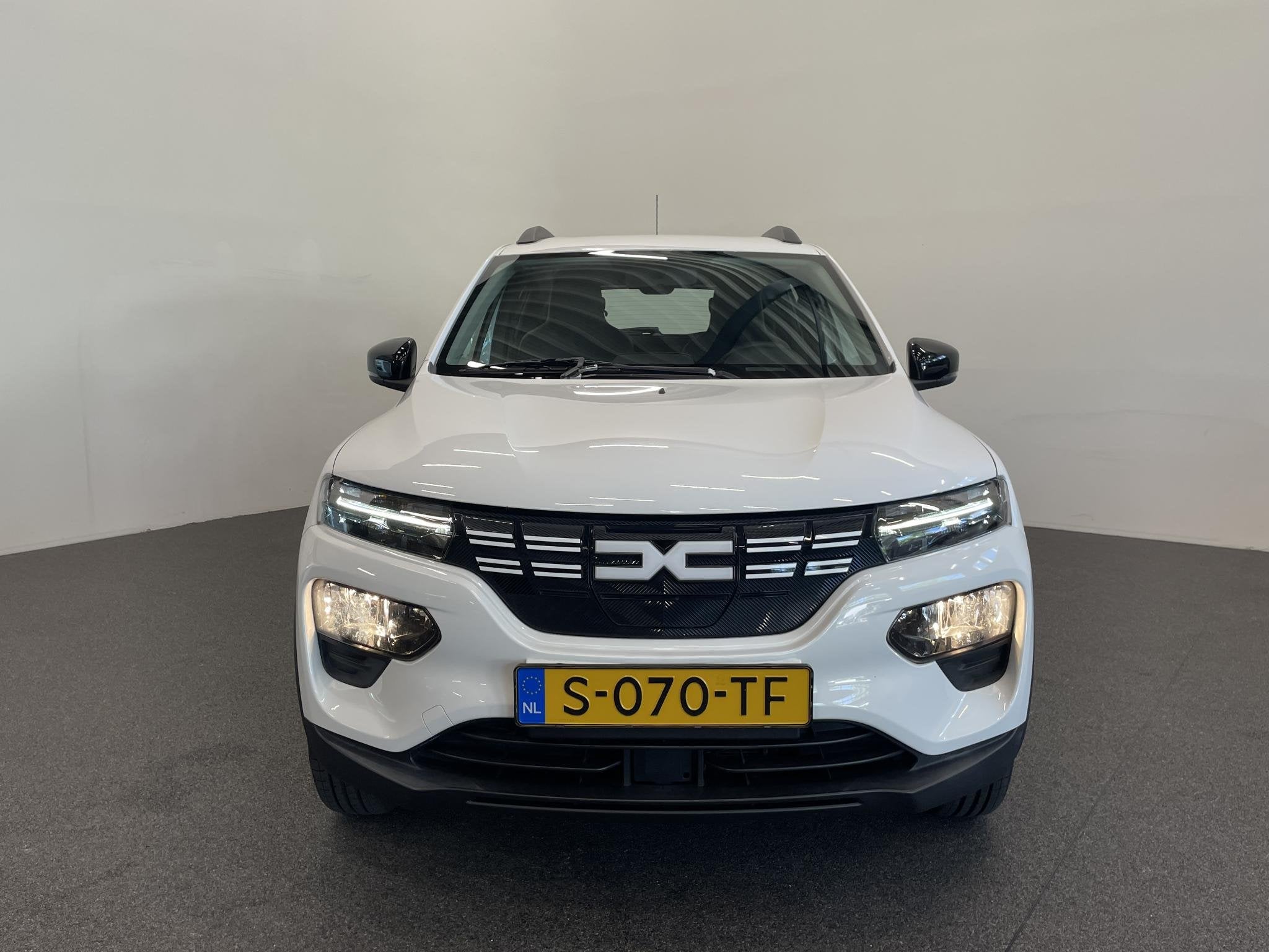 Dacia Spring Essential 27 kWh Airco, Auto's, Gebruikt, Zwart, Leder en Stof, Wit
