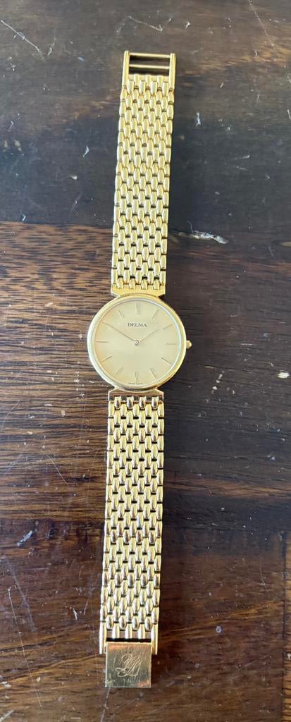 Vintage Delma polshorloge met goudkleurige band., Overige merken, Staal, Gebruikt, Staal