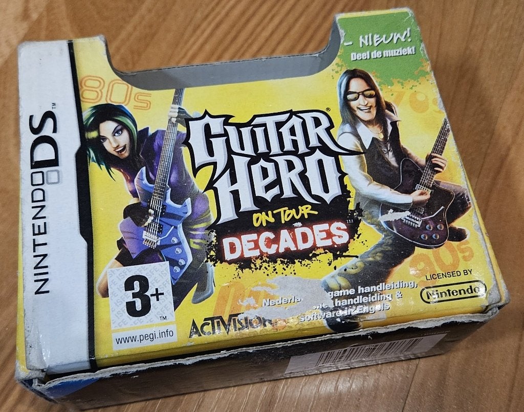Guitar Hero On Tour Decades - Game + Guitar Grip - set, Spelcomputers en Games, Games | Nintendo DS, Muziek, 1 speler, Ophalen of Verzenden
