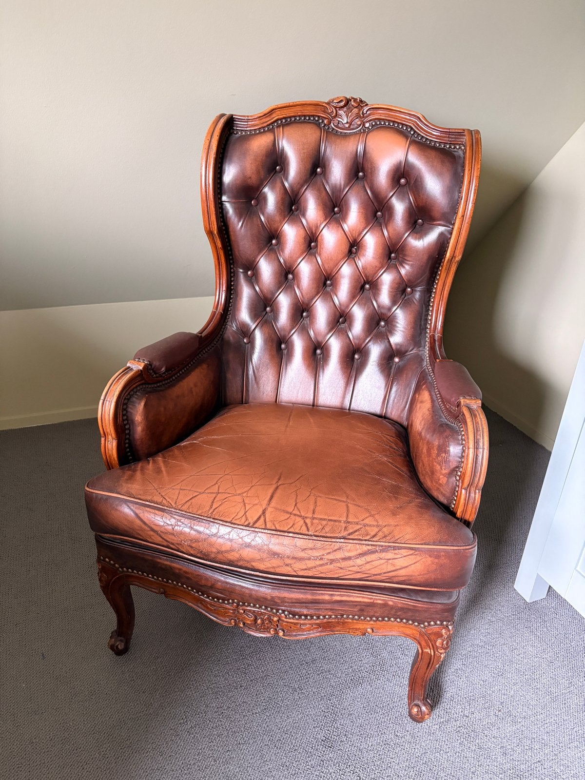 Authentieke leren fauteuil met rijk versierd houtwerk, Ophalen of Verzenden