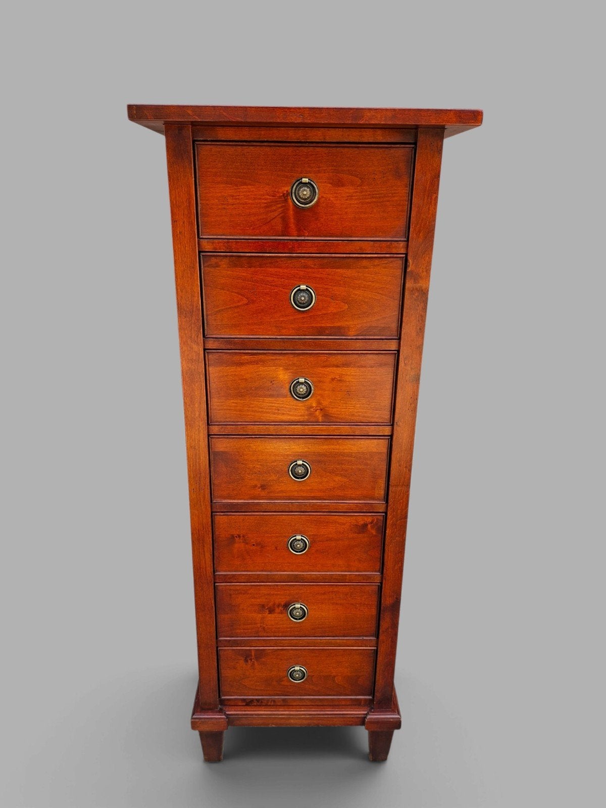 klassieke houten ladekast met zeven laden in een warme roodb