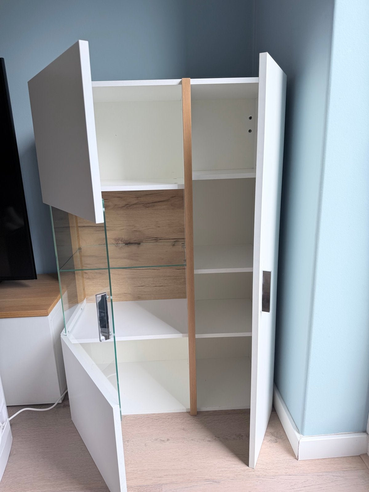 Foto 2 van Witte wandkast met glazen vitrine en houten accenten