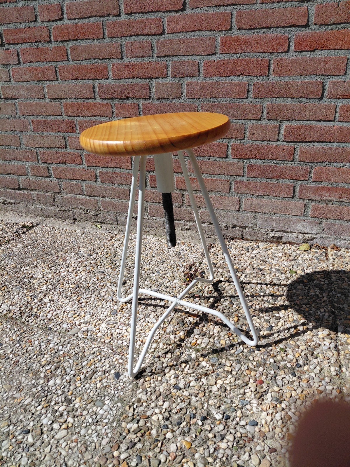 In hoogte verstelbaar krukje met houten zitting, Ophalen