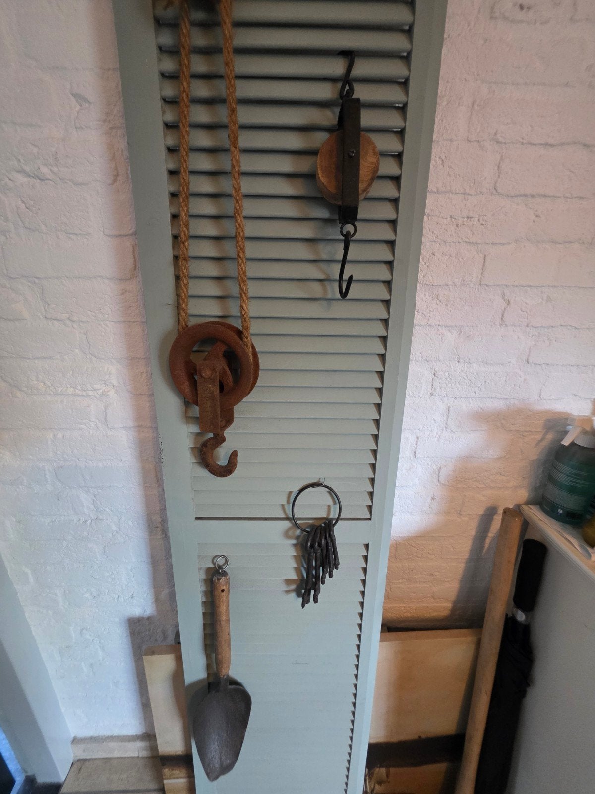 Decoratieve luik met katrollen en tuingereedschap, Ophalen