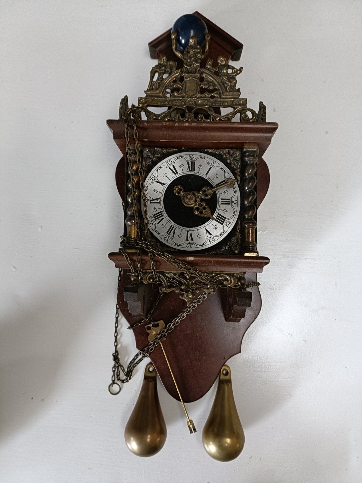 Antieke wandklok met kettingen en gewichten, Ophalen