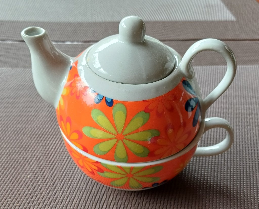Tea for one theekannetje en kopje oranje wit bloem ( Jola ), Ophalen of Verzenden, Zo goed als nieuw, Overige stijlen, Kop(pen) en/of Schotel(s)
