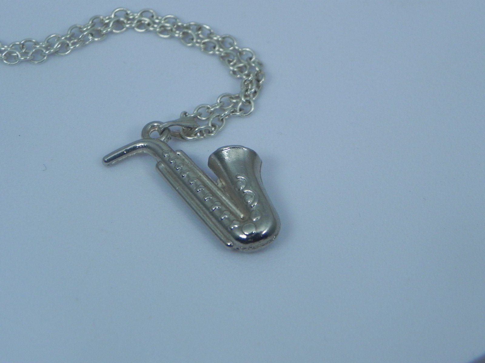 Zilverkleurige ketting met Saxofoon hanger, Sieraden, Tassen en Uiterlijk, Kettingen, Verzenden, Nieuw, Zilver, Overige materialen