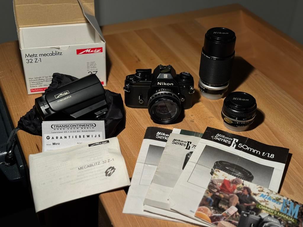 Complete Nikon EM set met 3 objectieven, flitser en papieren, Audio, Tv en Foto, Fotocamera's Analoog, Ophalen of Verzenden, Zo goed als nieuw
