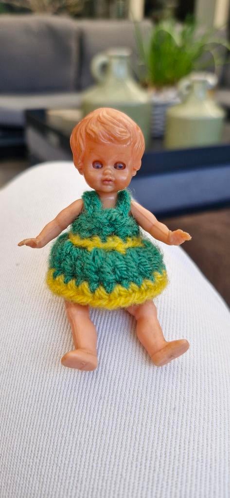 Oud plastic mini babypopje met gehaakt jurkje, Verzamelen, Poppen, Ophalen of Verzenden, Gebruikt, Babypop