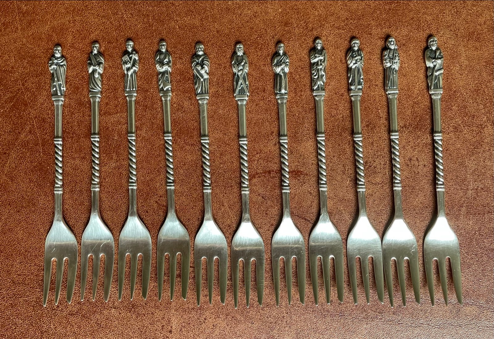 Set van 11 verzilverde gebaksvorkjes met apostelbeeldjes, Ophalen of Verzenden
