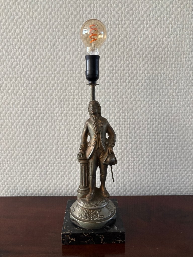 Antieke metalen lamp van een man staand naast een zuil., Ophalen of Verzenden